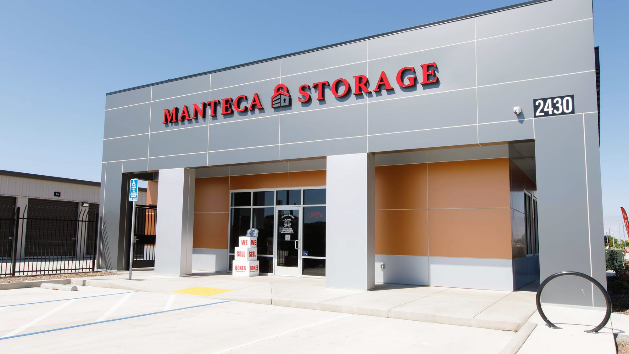 Manteca Storage's office at 2430 W Atherton Dr, with red MANTECA STORAGE lettering and a WE SELL BOXES display